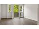 Bright bedroom with hardwood floors and a patio door leading to a balcony with a nature view at 11554 Serenbe Ln, Chattahoochee Hills, GA 30268