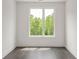 Bright, airy bedroom with hardwood floors and a large window offering wooded views at 11554 Serenbe Ln, Chattahoochee Hills, GA 30268