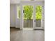 Light-filled room featuring wood floors and a door to a deck with a serene view of lush greenery at 11554 Serenbe Ln, Chattahoochee Hills, GA 30268