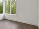 Bright, empty room with hardwood flooring and a corner window showcasing an expansive natural view at 11554 Serenbe Ln, Chattahoochee Hills, GA 30268