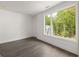 A bright bedroom with hardwood floors and a large window offering wooded views at 11554 Serenbe Ln, Chattahoochee Hills, GA 30268