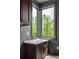 Convenient laundry room features a sink, stylish cabinets, and a large corner window offering a view at 11554 Serenbe Ln, Chattahoochee Hills, GA 30268