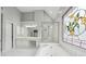 Elegant bathroom with a soaking tub, glass enclosed shower, and large stained glass window at 2645 Preston Ridge Ln, Dacula, GA 30019