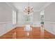 Elegant dining room with hardwood flooring, chandelier, wainscoting, and french doors at 2645 Preston Ridge Ln, Dacula, GA 30019