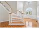 Inviting foyer with curved staircase, gleaming hardwood floors, and arched doorway at 2645 Preston Ridge Ln, Dacula, GA 30019