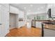 Well-lit kitchen with stainless appliances, wood flooring, granite counters, and white cabinets at 2645 Preston Ridge Ln, Dacula, GA 30019