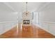 Open living area with hardwood floors, wainscoting, fireplace, and chandelier at 2645 Preston Ridge Ln, Dacula, GA 30019