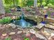 Landscaped pond and waterfall feature enhances the outdoor space, surrounded by lush greenery at 2645 Preston Ridge Ln, Dacula, GA 30019