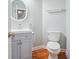 Charming powder room with round mirror, vanity, toilet, and hardwood floors at 2645 Preston Ridge Ln, Dacula, GA 30019