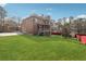 Beautifully landscaped backyard view of the brick home, featuring a garage and screened-in porch at 2656 Old Norcross Rd, Tucker, GA 30084
