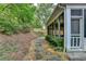 Side view of a backyard with a stone pathway, landscaping, and the side of the screened-in porch at 3003 Heavenly Ln, Snellville, GA 30078