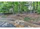 A quaint backyard features a stone pathway leading to a wooded area and a wooden fence at 3003 Heavenly Ln, Snellville, GA 30078