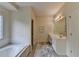 Bright bathroom features a soaking tub, double sinks, and updated marble flooring at 3003 Heavenly Ln, Snellville, GA 30078