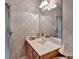 Chic bathroom features a vanity, soft wallpaper, a decorative mirror, and a window, exuding style and functionality at 3003 Heavenly Ln, Snellville, GA 30078