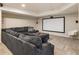 Finished basement featuring a large sectional sofa, projector screen, and neutral carpet at 310 Tradea Tarn, Roswell, GA 30076