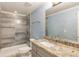 Bathroom featuring a shower with grey tile, granite counters, and an undermount sink at 310 Tradea Tarn, Roswell, GA 30076