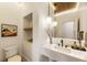 Stylish powder room with modern fixtures, a floating vanity, and a decorative mirror at 310 Tradea Tarn, Roswell, GA 30076
