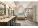 Luxurious bathroom features double vanity, freestanding tub, and glass-enclosed shower at 310 Tradea Tarn, Roswell, GA 30076