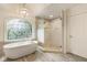 Beautiful bathroom featuring soaking tub by window and glass enclosed shower at 310 Tradea Tarn, Roswell, GA 30076