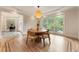 Dining area with hardwood floors, a round wooden table with modern chairs, and a large window at 310 Tradea Tarn, Roswell, GA 30076