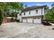 Modern exterior with three-car garage and stone facade at 310 Tradea Tarn, Roswell, GA 30076