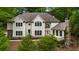 Stunning home featuring manicured landscaping, a stone chimney, and an inviting entrance with a large window feature at 310 Tradea Tarn, Roswell, GA 30076