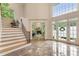 Bright foyer boasts high ceilings, large windows, tile floors, and staircase with wood treads and modern railing at 310 Tradea Tarn, Roswell, GA 30076