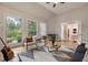 Bright living room with fireplace, hardwood floors, modern furniture, and three large windows offering a scenic view at 310 Tradea Tarn, Roswell, GA 30076