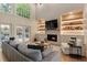 Bright living room features a fireplace, custom shelving, hardwood floors, and French doors to an outdoor patio at 310 Tradea Tarn, Roswell, GA 30076