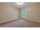 Cozy bedroom with neutral carpet, paint and trim complemented by natural light from a window at 785 Redland Dr, Jonesboro, GA 30238