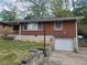 Charming brick home featuring an attached single-car garage and well-maintained front lawn at 1230 Lloyd Dr, Forest Park, GA 30297