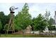 The backyard features a vintage windmill with a barn and landscaping at 12520 Celestine Way, Milton, GA 30075