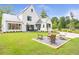 Spacious backyard featuring a fire pit and outdoor seating with a modern farmhouse-style house in the background at 12520 Celestine Way, Milton, GA 30075