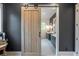 A peek into the bathroom through a rustic barn door, showing double vanities and mirrors at 12520 Celestine Way, Milton, GA 30075