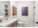 Chic powder room with a modern vanity, decorative art, and floating shelves for stylish storage at 12520 Celestine Way, Milton, GA 30075