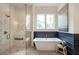 Modern bathroom featuring a soaking tub, glass enclosed shower and large window at 12520 Celestine Way, Milton, GA 30075