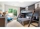 Stylish bunk room features a built-in bunk bed with a ladder and a charming window view of the verdant landscape at 12520 Celestine Way, Milton, GA 30075