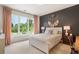 Stylish bedroom featuring a plush bed, large window and modern decor at 12520 Celestine Way, Milton, GA 30075