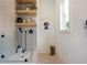 Delightful dog wash station featuring a gray tile surround, shelving, and herringbone flooring at 12520 Celestine Way, Milton, GA 30075