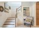 Bright foyer with a staircase, attractive mirror, and a comfortable chair, creating a welcoming entrance at 12520 Celestine Way, Milton, GA 30075