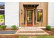 Charming home entrance with a red door, brick steps, and craftsman-style wood accents at 12520 Celestine Way, Milton, GA 30075