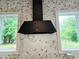 Close up of range hood and marble backsplash, flanked by large windows at 12520 Celestine Way, Milton, GA 30075