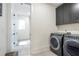 Modern laundry room with gray cabinets, and stainless steel washer and dryer at 12520 Celestine Way, Milton, GA 30075
