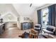 Attic space with stylish decor, wooden floors, and comfortable seating next to a glass coffee table and chessboard at 12520 Celestine Way, Milton, GA 30075