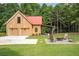 Spacious outbuilding with a red roof, garage doors, and cozy fire pit area with seating at 12520 Celestine Way, Milton, GA 30075