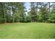 Lush backyard featuring a vast lawn and mature trees, creating a serene outdoor space at 3003 Butler Creek Nw Rd, Kennesaw, GA 30152