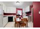 Eat-in kitchen with black appliances, white cabinets, and wood table offers a cozy space at 3003 Butler Creek Nw Rd, Kennesaw, GA 30152