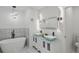 Luxurious bathroom featuring double vanities, a soaking tub, and modern lighting fixtures at 3634 Oakleaf Pass, Fairburn, GA 30213