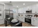 Well-lit kitchen featuring stainless steel appliances, white cabinets, and modern fixtures at 3634 Oakleaf Pass, Fairburn, GA 30213