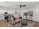 Sun-filled living room featuring modern decor, a ceiling fan, and an open layout to the kitchen at 3634 Oakleaf Pass, Fairburn, GA 30213